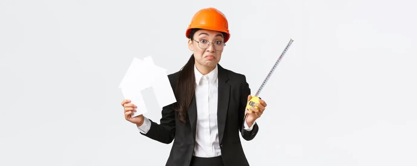 Confused, indecisive Asian female architect/engineer in a helmet and business suit, unsure what to do.